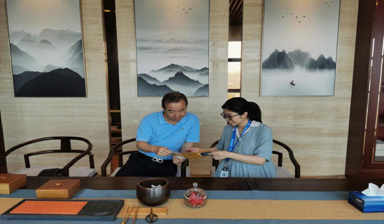 民生银行厦门分行客户经理陈婷婷（右）向张长峰介绍小微金融产品。