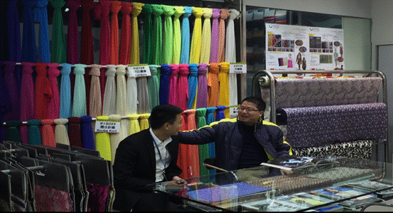 民生银行广州分行员工（左）走访新恒胜布行。